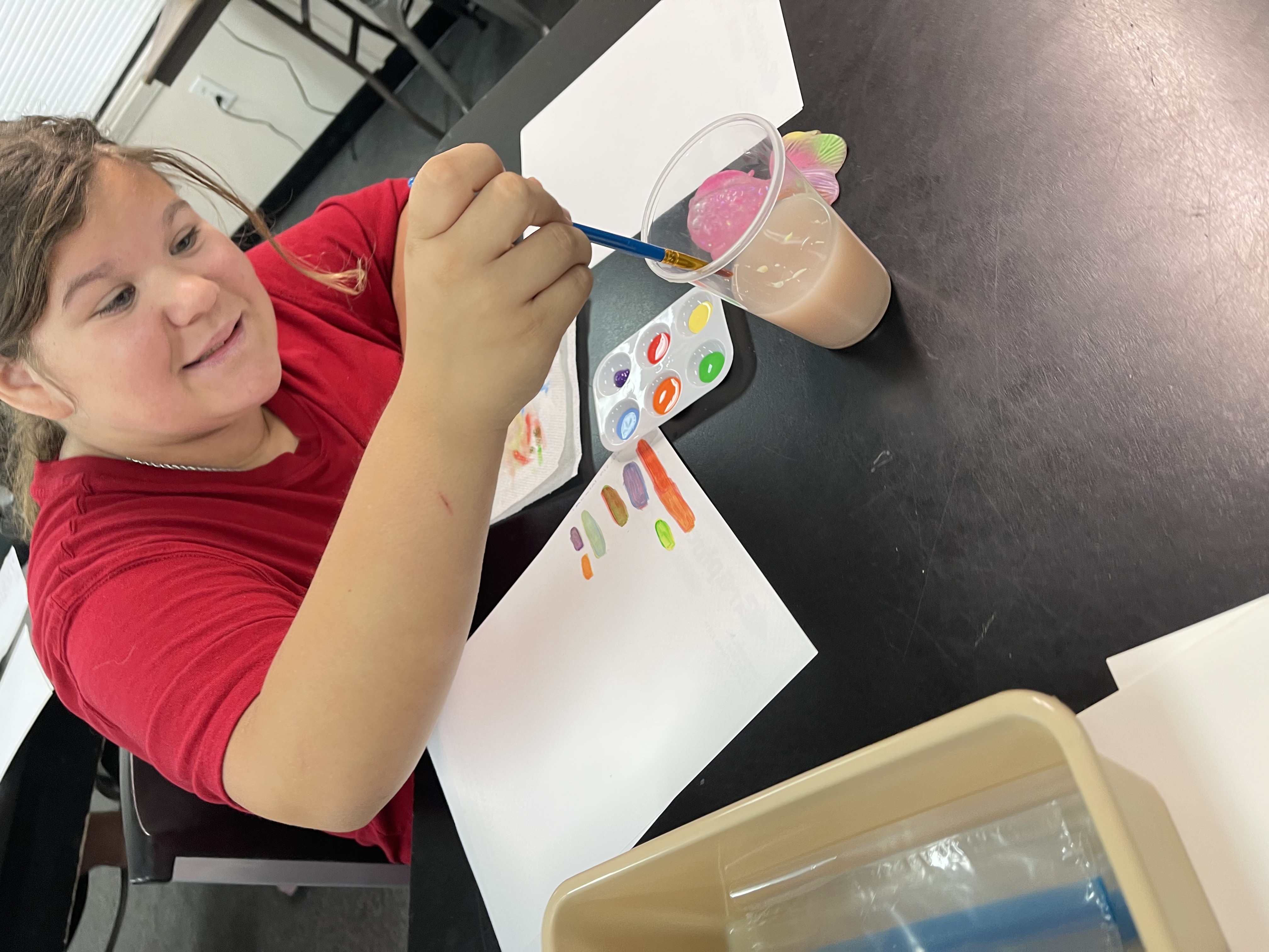 Student proudly holding completed artwork